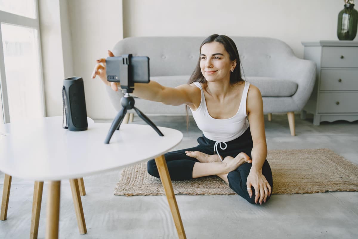 A creator setting up a phone on a tripod to film in a bright living room